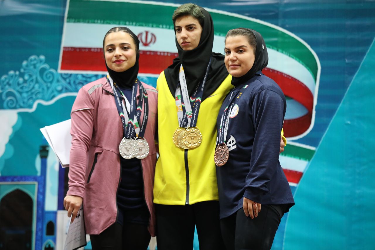 نتایج مسابقات وزنه برداری قهرمانی بانوان کشور به میزبانی اصفهان 4 پس از مشخص شدن نتایج کامل مسابقات وزنه برداری قهرمانی بانوان کشور به میزبانی اصفهان، تیم های برتر روی سکو ایستادند. به گزارش یاریزان؛ مریم ایلکا سرپرست نایب رییسی بانوان در فدراسیون وزنه برداری کشور اظهارداشت: سال گذشته پنجمین دوره مسابقات کشوری بانوان در شهر اردبیل و با میزبانی بسیار خوب هیات این استان برگزار شد. در آن رویداد ۴۶ ورزشکار خانم از ۱۹ استان رقابت کردند اما امسال شاهد هستیم که ششمین دوره با حضور ۱۰۱ وزنه بردار از ۲۲ استان در حال برگزاری است. به اعتقاد ایلکا، توجه و حمایت فدراسیون از وزنه برداری بانوان، موفقیت های دختران در مسابقات بین المللی و پویاتر شدن هیات های استانی قطعا یکی از عوامل مهم در جذب ورزشکاران خانم بوده است. نایب رییس بانوان ابراز امیدواری کرد از دل این رویداد که مهمترین مسابقه برای ارزیابی و شناسایی پتانسیل های وزنه برداری بانوان در سطح داخلی است، چهره های مستعد و آینده ساز برای دعوت به تیم های ملی بیرون آیند. تیم وزنه برداری دختران اصفهان با کسب 9 مدال طلا، روی سکوی نخست رده بندی بهترین تیم های ششمین دوره رقابتهای قهرمانی بزرگسالان کشور ایستاد تا کاپ قهرمانی در خانه میزبان بماند. عنوان دومی این رقابت ها به تیم البرز تعلق گرفت که با بیشترین مدالها شامل چهار طلا، پنج نقره و چهار برنز، تیم دوم و صاحب کاپ نقره مسابقات قهرمانی کشور شد. نهایتا چهار مدال طلا و پنج مدال برنز کاپ سومی را برای تیم خراسان رضوی به ارمغان آورد. نتایج کامل رده بندی مدالی استان ها به شرح زیر است: 1 - اصفهان 9 مدال طلا 2 - البرز 4 طلا 5 نقره و 4 برنز 3 - خراسان رضوی 4 طلا و 5 برنز 4 - خوزستان 3 طلا، 6 نقره و 1 برنز 5 - زنجان 3 طلا، 3 نقره و 2 برنز 6- کردستان 3 طلا 7 - لرستان 2 طلا، 3 نقره و 1 برنز 8 - کرمان 2 طلا و 1 نقره 9 - کرمانشاه 3 نقره و 3 برنز 10 - تهران 3 نقره و 1 برنز 11 - همدان 3 نقره نتایج پایانی رقابتهای وزنهبرداری قهرمانی بانوان کشور دسته ۴۵ کیلوگرم بانوان یکضرب ساناز مددی کرمان : ۴۰ کیلوگرم مهیا محمدی خوزستان : ۳۶ کیلوگرم فاطمه نصیری خراسان رضوی: ۳۵ کیلوگرم دوضرب فاطمه نصیری خراسان رضوی: ۵۱کیلوگرم ساناز مددی کرمان: ۵۰ کیلوگرم مهیا محمدی خوزستان: ۵۰ کیلوگرم مجموع ساناز مددی کرمان: ۹۰ کیلوگرم مهیا محمدی خوزستان: ۸۶ کیلوگرم فاطمه نصیری خراسان رضوی: ۸۶ کیلوگرم نتایج پایانی رقابت های وزنه برداری قهرمانی بانوان کشور دسته ۴۹ کیلوگرم بانوان یکضرب پگاه لیاقت اصفهان : ۵۰ کیلوگرم گلاب مرادی کرمانشاه: ۴۸ کیلوگرم زهرا اهدایی البرز: ۴۰ کیلوگرم دوضرب پگاه لیاقت اصفهان: ۶۶کیلوگرم گلاب مرادی کرمانشاه: ۶۰کیلوگرم مریم اسکندری فارس: ۵۱ کیلوگرم مجموع پگاه لیاقت اصفهان: ۱۱۶ کیلوگرم گلاب مرادی کرمانشاه: ۱۰۸ کیلوگرم مریم اسکندری فارس: ۹۱ کیلوگرم نتایج پایانی مسابقات بانوان کشور دسته ۵۵ کیلوگرم بانوان یکضرب پرنیان پیش بین اصفهان : ۷۳ کیلوگرم کیانا ترک بیات همدان: ۵۶ کیلوگرم مهسا دهقان خراسان رضوی: ۵۵ کیلوگرم دوضرب پرنیان پیش بین اصفهان: ۸۵ کیلوگرم کیانا ترک بیات همدان: ۷۳ کیلوگرم مهسا دهقان خراسان رضوی: ۷۲ کیلوگرم مجموع پرنیان پیش بین اصفهان ۱۵۸ کیلوگرم کیانا ترک بیات همدان : ۱۲۹ کیلوگرم مهسا دهقان خراسان رضوی: ۱۲۷ کیلوگرم نتایج پایانی رقابت های قهرمانی بانوان کشور دسته ۵۹ کیلوگرم بانوان حرکت یکضرب شینا امانی - کردستان - 78 کیلوگرم بهنوش باقرزاده - البرز - 76 کیلوگرم پوپک بسامی - کرمانشاه - 71 کیلوگرم حرکت دوضرب شینا امانی کردستان - 95 کیلوگرم بهنوش باقرزاده البرز - 95 کیلوگرم پوپک بسامی کرمانشاه - 89 کیلوگرم مجموع شینا امانی - کردستان - 173 کیلوگرم بهنوش باقرزاده - البرز - 171 کیلوگرم پوپک بسامی - کرمانشاه - 160 کیلوگرم نتایج پایانی مسابقات وزنهبرداری قهرمانی بانوان کشور دسته ۶۴ کیلوگرم بانوان حرکت یکضرب هانیه خسروی - خوزستان - 83 کیلوگرم فاطمه مرادی - تهران - 69 کیلوگرم نگین اسدی - البرز - 67 کیلوگرم دوضرب هانیه خسروی - خوزستان - 104 کیلوگرم فاطمه مرادی - تهران - 93 کیلوگرم نگین اسدی - البرز - 85 کیلوگرم مجموع هانیه خسروی - خوزستان - 187 کیلوگرم فاطمه مرادی - تهران - 162 کیلوگرم نگین اسدی - البرز - 152 کیلوگرم نتایج پایانی رقابتهای قهرمانی بانوان کشور دسته 71 کیلوگرم بانوان یکضرب زهرا زارعی - اصفهان - 88 کیلوگرم نازنین معتمدی - لرستان - 87 کیلوگرم فروغ یونسی - بوشهر - 86 کیلوگرم دوضرب زهرا زارعی - اصفهان - 109 کیلوگرم فروغ یونسی - بوشهر - 108 کیلوگرم نازنین معتمدی - لرستان - 107 کیلوگرم مجموع زهرا زارعی - اصفهان - 198 کیلوگرم نازنین معتمدی - لرستان - 194 کیلوگرم فروغ یونسی - بوشهر - 194 کیلوگرم نتایج پایانی مسابقات وزنه برداری قهرمانی بانوان کشور دسته 76 کیلوگرم بانوان یکضرب ندا قادری پور - خراسان رضوی - 83 کیلوگرم زهرا سلامت - خوزستان - 82 کیلوگرم مرضیه بهمیه - فارس - 77 کیلوگرم دوضرب ندا قادری پور - خراسان رضوی - 110 کیلوگرم مرضیه بهمیه - فارس - 96 کیلوگرم شیما نوروزی - زنجان - 90 کیلوگرم مجموع ندا قادری پور - خراسان رضوی - 193 کیلوگرم مرضیه بهمیه - فارس - 173 کیلوگرم زهرا مصطفایی - زنجان - 165 کیلوگرم نتایج پایانی رقابت های بانوان کشور دسته 76 کیلوگرم بانوان حرکت یکضرب الهه رزاقی - زنجان - 99 کیلوگرم زهرا سلحشور - خوزستان - 86 کیلوگرم سحر زارع - فارس - 77 کیلوگرم حرکت دوضرب الهه رزاقی (زنجان) 130 کیلوگرم زهرا سلحشور (خوزستان) 117 کیلوگرم سحر زارع (فارس) 108 کیلوگرم مجموع الهه رزاقی - زنجان - 229 کیلوگرم زهرا سلحشور - خوزستان - 203 کیلوگرم سحر زارع - فارس - 185 کیلوگرم نتایج پایانی مسابقات وزنه برداری قهرمانی بانوان کشور دسته ۸۷ کیلوگرم بانوان یکضرب سیده الهام حسینی - لرستان:۱۰۱ کیلوگرم زینب شیخ حسن ارباب - البرز: ۹۳ کیلوگرم افسانه احمدیان - سمنان: ۵۸ کیلوگرم دوضرب زینب شیخ حسن ارباب - البرز: ۱۳۲کیلوگرم سیده الهام حسینی - لرستان:۱۳۱کیلوگرم مجموع سیده الهام حسینی) لرستان:۲۳۲کیلوگرم زینب شیخ حسن ارباب) البرز: ۲۲۵کیلوگرم نتایج پایانی رقابت های قهرمانی بانوان کشور دسته ۸۷+ کیلوگرم بانوان یکضرب نرگس میرزکی - البرز: ۸۶ کیلوگرم مائده نصیری - زنجان: ۷۸ کیلوگرم فاطمه محسنی امیر - تهران: ۶۰ کیلوگرم دوضرب نرگس میرزکی - البرز:۱۰۷کیلوگرم مائده نصیری) - زنجان: ۹۷کیلوگرم نگار امرودی - خراسان جنوبی:۵۳ کیلوگرم مجموع نرگس میرزکی - البرز: ۱۹۳ کیلوگرم مائده نصیری - زنجان: ۱۷۵ کیلوگرم نگار امرودی - خراسان جنوبی: ۹۴ کیلوگرم