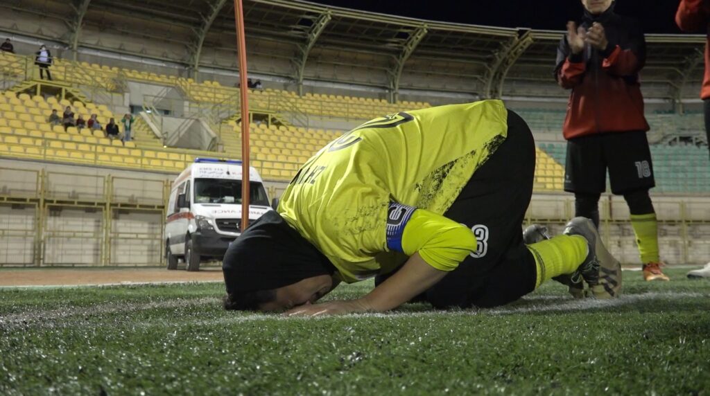 فصل جدید لیگ برتر فوتبال زنان، یک غایب شاخص دارد. زهرا حاتم نژاد ستاره فوتبال ایلام به دوران باشکوه خود پایان داده است. به گزارش یاریزان، لیگ برتر فوتبال زنان امسال بدون حضور ستاره وفادار ایلامی‌ها برگزار خواهد شد؛ بازیکنی که نام او سال‌ها در جدول گلزنان می‌درخشید. زهرا حاتم نژاد، مهاجم پالایش‌گاز ایلام، این فصل دیگر در میادین حضور نخواهد داشت؛ بازیکنی که بخش اعظم عمر فوتبالی خود را در ترکیب تیم پالایش گاز ایلام یا نمایندگان غرب کشور سپری کرده است. اولین لیگ بدون زهرا، یعنی نخستین فصل، بدون خانم‌گلی که یک‌بار با ۲۷ گل، تمام رکوردها را شکست و با بیش از ۱۰۰ گل در لیگ برتر یکی از اعضای باشگاه صدتایی های لیگ فوتبال زنان است. زهرا حاتم‌نژاد متولد شهریور ۶۵ در ایلام است و درست مثل لهجه‌اش، فوتبالی هم داشت که رنگ خاک شهرش را حفظ کرد. زهرا ۱۷ سال در لیگ برتر بازی کرد، دوازده سال پیراهن تیم ملی را پوشید، در مقدماتی المپیک لندن گل زد و سبب صعود تیم ملی به دور دوم المپیک شد . او در مقدماتی المپیک ریو و جام ملت‌های آسیا جنگید و در ۱۴ فصل پیراهن پالایش‌گاز را عوض نکرد تا نمادی بزرگ برای پالایش گاز ایلام و الگوی وفاداری برای این باشگاه و شهرش باشد. کارنامه‌اش پر است از عنوان و جام؛ قهرمانی در لیگ برتر، خانم‌گلی، حضور در تیم ملی، قهرمانی در لیگ ساحلی با داماش گیلان و حتی تجربه مربیگری فوتسال و فوتبال پایه. هرجا که توپ بود، زهرا هم بود و همیشه هم با همان بازوبند کاپیتانی که سال‌ها به بازویش چسبیده بود؛ آن هم در دورانی که تبدیل شدن یک دختر به فوتبالیستی حرفه‌ای چندان معمول نبود. حالا که فصل بدون او شروع می‌شود، جای خالی‌اش فقط در جدول گلزنان هویدا نیست. این خلا، در نفس حملات پالایش‌گاز، در التهاب محوطه جریمه و حتی در برق چشم دختراننوجوانی که روزی آرزو داشتند مثل او باشند هم دیده می‌شود. شاید زمان آن رسیده باشد که او خود را آماده ادامه خدمت به ایلام در نقشی تازه کند. تجربه شگرف سال‌ها حضور و درخشش در فوتبال زنان ایران، گنجینه‌ای است که می‌تواند در خدمت فوتبال ایلام و غرب کشور درآید؛ جایی که دختران علاقمند به فوتبال، بی‌اندازه محتاج دریافت این تجارب هستند. زهرا حاتم نژاد شاید از زمین بازی محو شده باشد، اما گل‌ها و تعصبش هنوز اینجا مانده‌اند. میراثی که با هیچ وداعی پاک نمی‌شود.