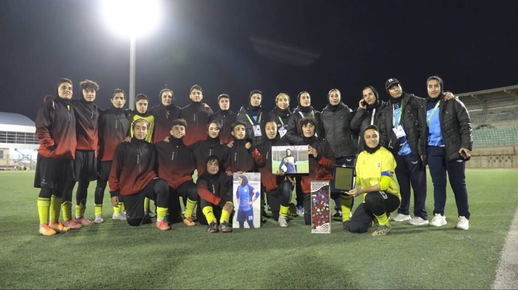 فصل جدید لیگ برتر فوتبال زنان، یک غایب شاخص دارد. زهرا حاتم نژاد ستاره فوتبال ایلام به دوران باشکوه خود پایان داده است. به گزارش یاریزان، لیگ برتر فوتبال زنان امسال بدون حضور ستاره وفادار ایلامی‌ها برگزار خواهد شد؛ بازیکنی که نام او سال‌ها در جدول گلزنان می‌درخشید. زهرا حاتم نژاد، مهاجم پالایش‌گاز ایلام، این فصل دیگر در میادین حضور نخواهد داشت؛ بازیکنی که بخش اعظم عمر فوتبالی خود را در ترکیب تیم پالایش گاز ایلام یا نمایندگان غرب کشور سپری کرده است. اولین لیگ بدون زهرا، یعنی نخستین فصل، بدون خانم‌گلی که یک‌بار با ۲۷ گل، تمام رکوردها را شکست و با بیش از ۱۰۰ گل در لیگ برتر یکی از اعضای باشگاه صدتایی های لیگ فوتبال زنان است. زهرا حاتم‌نژاد متولد شهریور ۶۵ در ایلام است و درست مثل لهجه‌اش، فوتبالی هم داشت که رنگ خاک شهرش را حفظ کرد. زهرا ۱۷ سال در لیگ برتر بازی کرد، دوازده سال پیراهن تیم ملی را پوشید، در مقدماتی المپیک لندن گل زد و سبب صعود تیم ملی به دور دوم المپیک شد . او در مقدماتی المپیک ریو و جام ملت‌های آسیا جنگید و در ۱۴ فصل پیراهن پالایش‌گاز را عوض نکرد تا نمادی بزرگ برای پالایش گاز ایلام و الگوی وفاداری برای این باشگاه و شهرش باشد. کارنامه‌اش پر است از عنوان و جام؛ قهرمانی در لیگ برتر، خانم‌گلی، حضور در تیم ملی، قهرمانی در لیگ ساحلی با داماش گیلان و حتی تجربه مربیگری فوتسال و فوتبال پایه. هرجا که توپ بود، زهرا هم بود و همیشه هم با همان بازوبند کاپیتانی که سال‌ها به بازویش چسبیده بود؛ آن هم در دورانی که تبدیل شدن یک دختر به فوتبالیستی حرفه‌ای چندان معمول نبود. حالا که فصل بدون او شروع می‌شود، جای خالی‌اش فقط در جدول گلزنان هویدا نیست. این خلا، در نفس حملات پالایش‌گاز، در التهاب محوطه جریمه و حتی در برق چشم دختراننوجوانی که روزی آرزو داشتند مثل او باشند هم دیده می‌شود. شاید زمان آن رسیده باشد که او خود را آماده ادامه خدمت به ایلام در نقشی تازه کند. تجربه شگرف سال‌ها حضور و درخشش در فوتبال زنان ایران، گنجینه‌ای است که می‌تواند در خدمت فوتبال ایلام و غرب کشور درآید؛ جایی که دختران علاقمند به فوتبال، بی‌اندازه محتاج دریافت این تجارب هستند. 